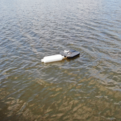 Aerial shot of the new ultrasonic algae destroyer, which hangs not far below the surface from the panel floating on top the surface.