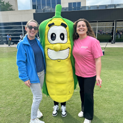 Emily Garner and Melinda Sampson pose with Corn mascot at Roar, Soar, Explore Night