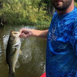 Vincent holding a fish that he caught in the river.