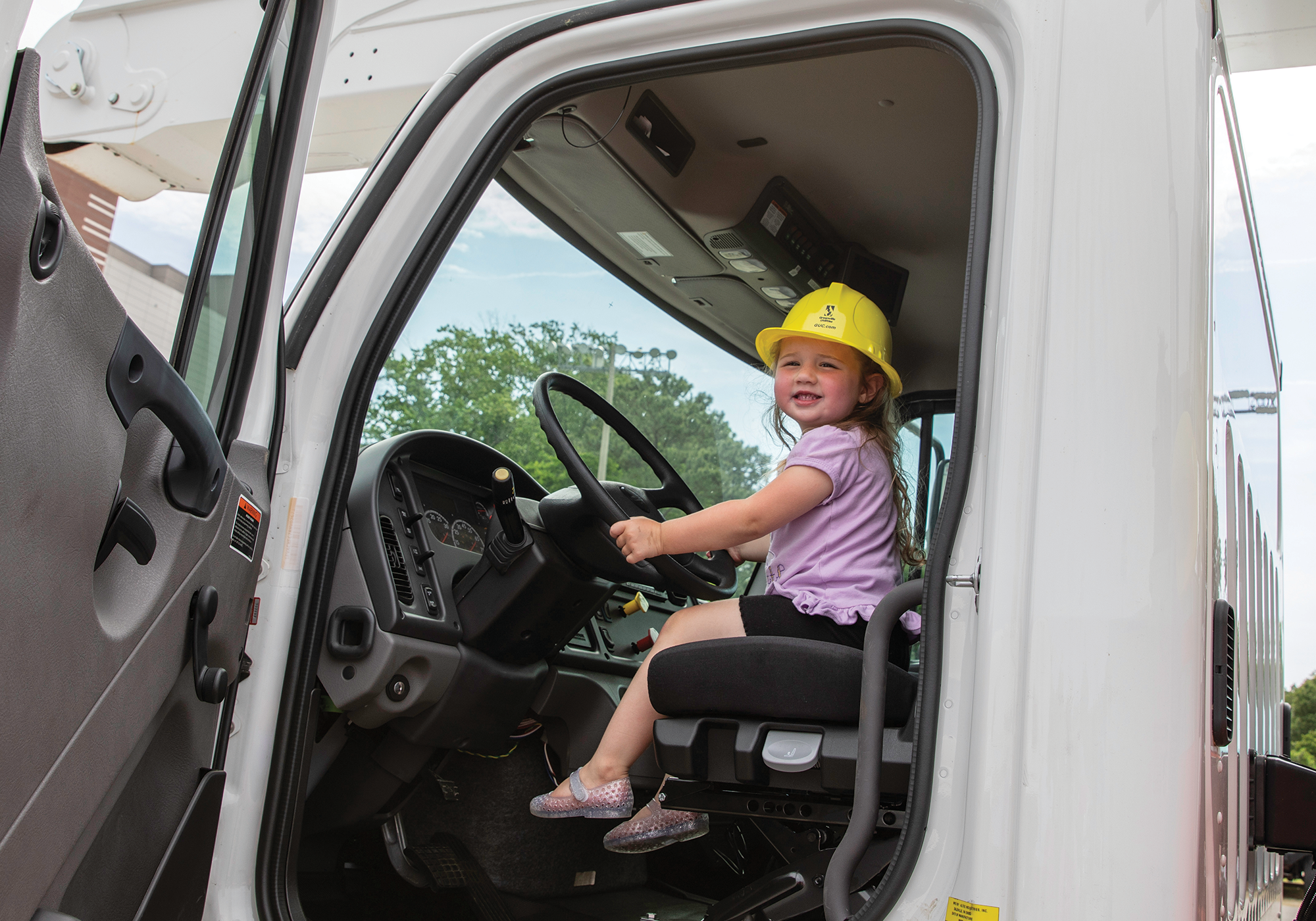 Child exploring a bucket truck at a Touch-A-Truck event