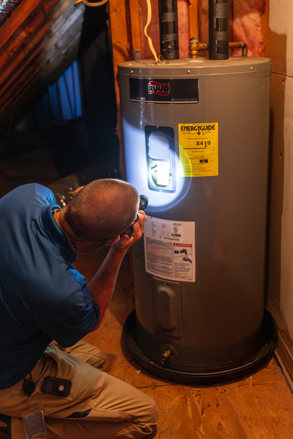 Jonathan inspects a customers water heater.