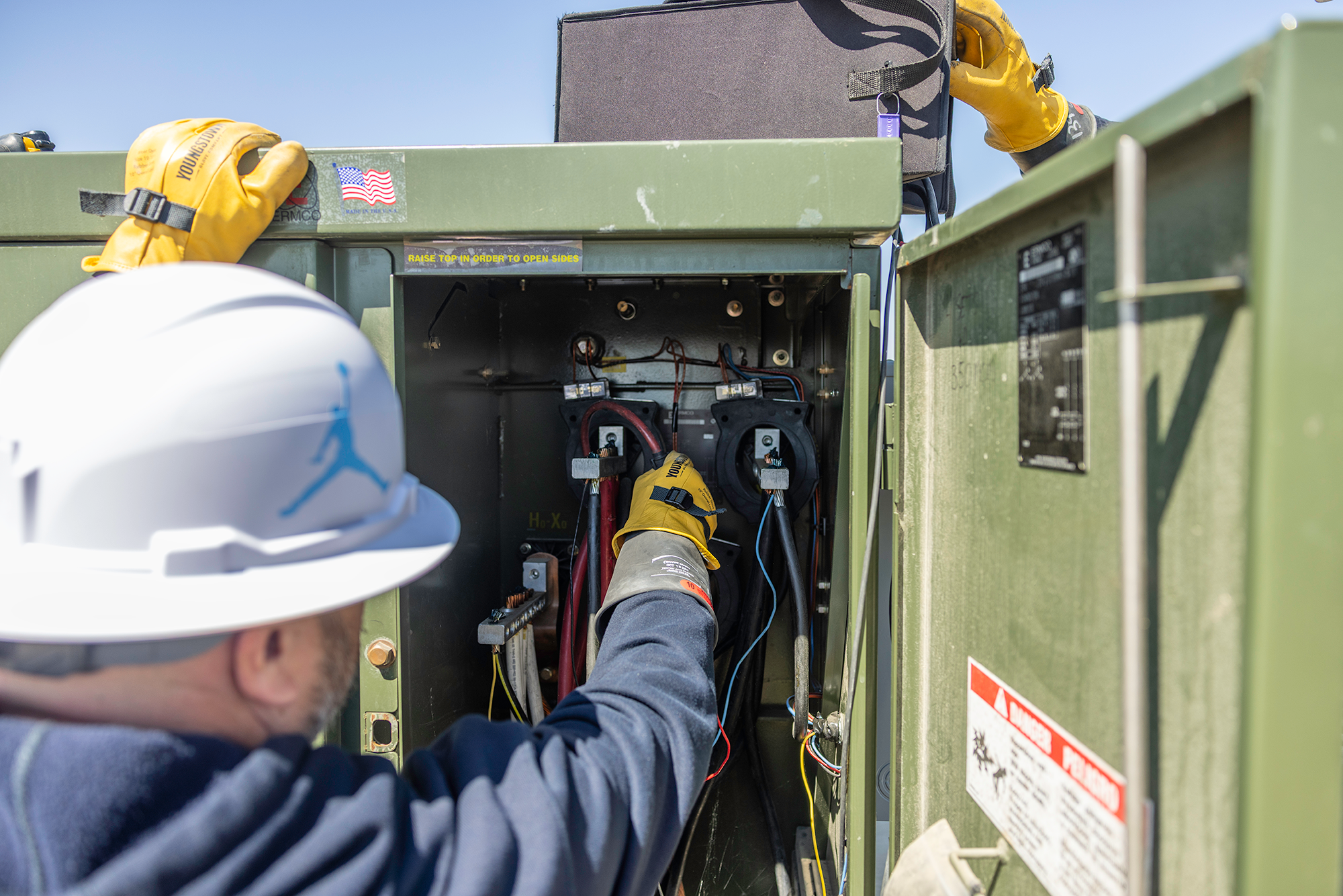 Meter technician inspects commercial electric meter