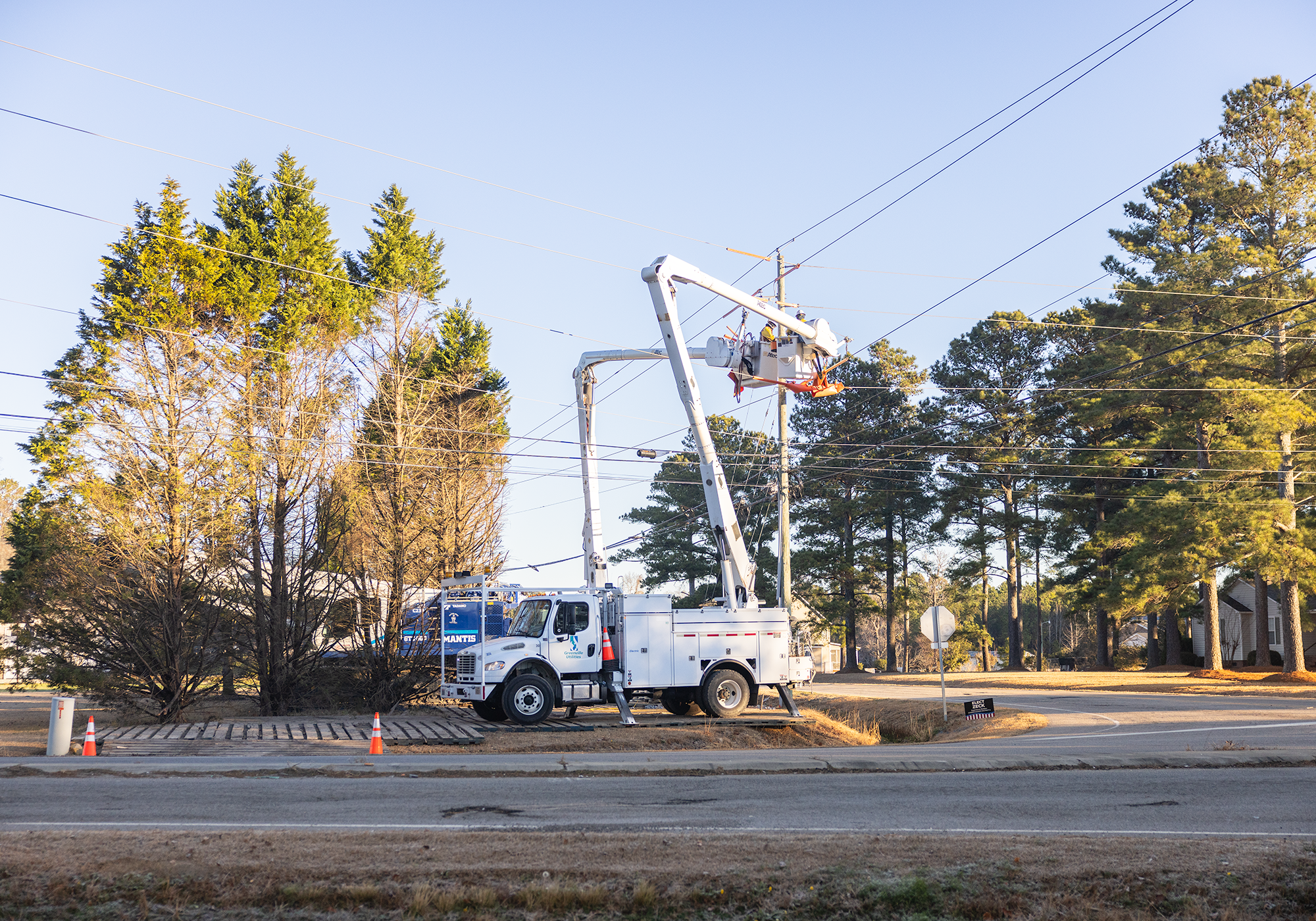 Two linemen in bucket trucks