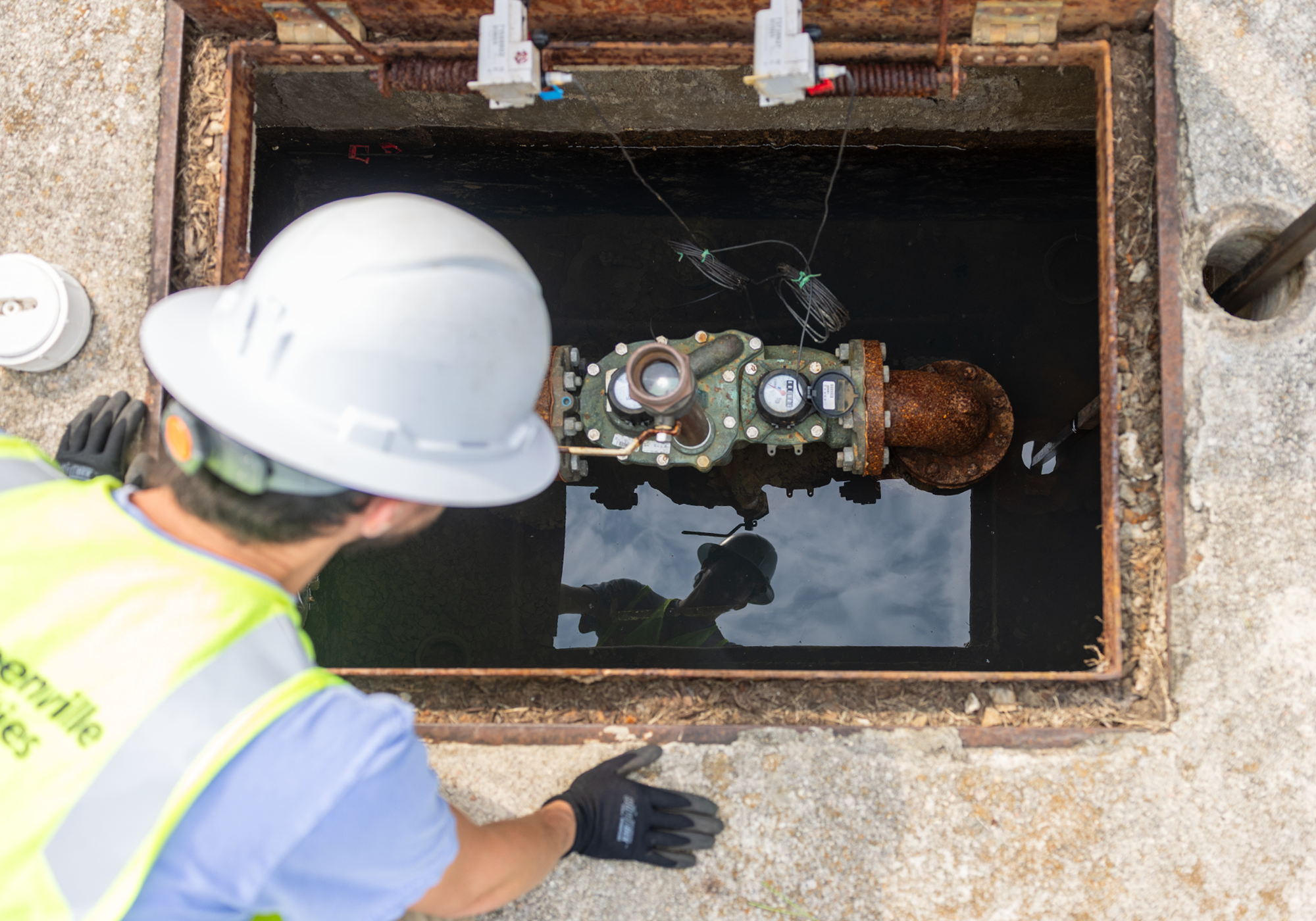 Quentin inspects a large meter, ensuring it is turned off.