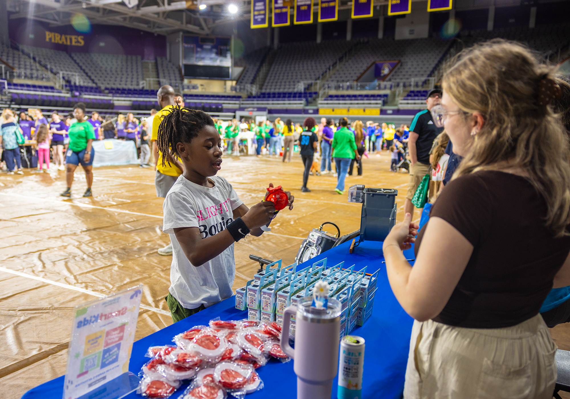 Public Information Intern Parker Lee chats with a student at the Roar, Soar, Explore Community Bash.