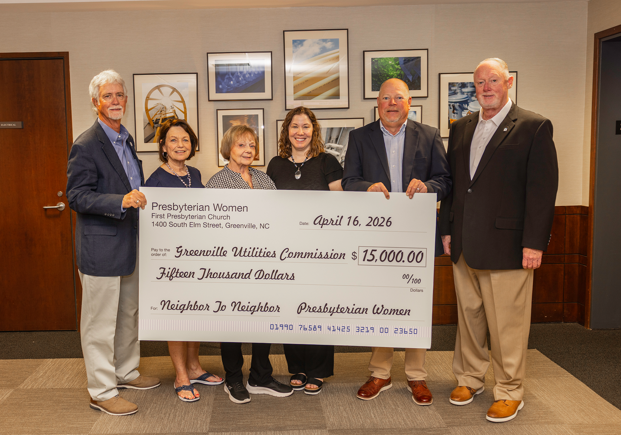 Group of people holding a large check in the amount of $15,000