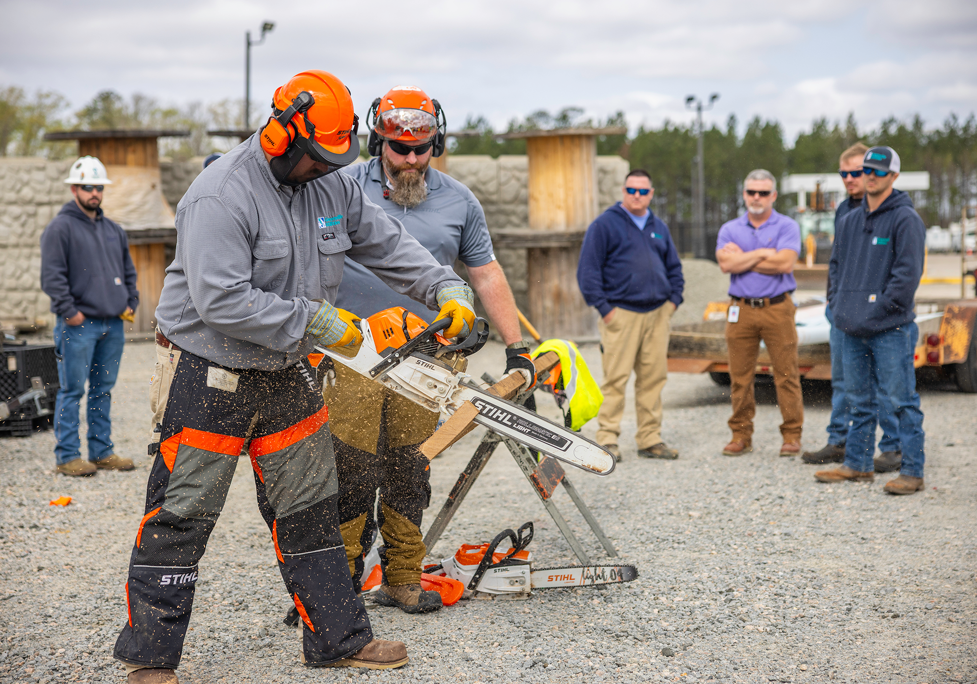 Gas Systems Crew Leader I Chris Bright learns how to operate a chainsaw
