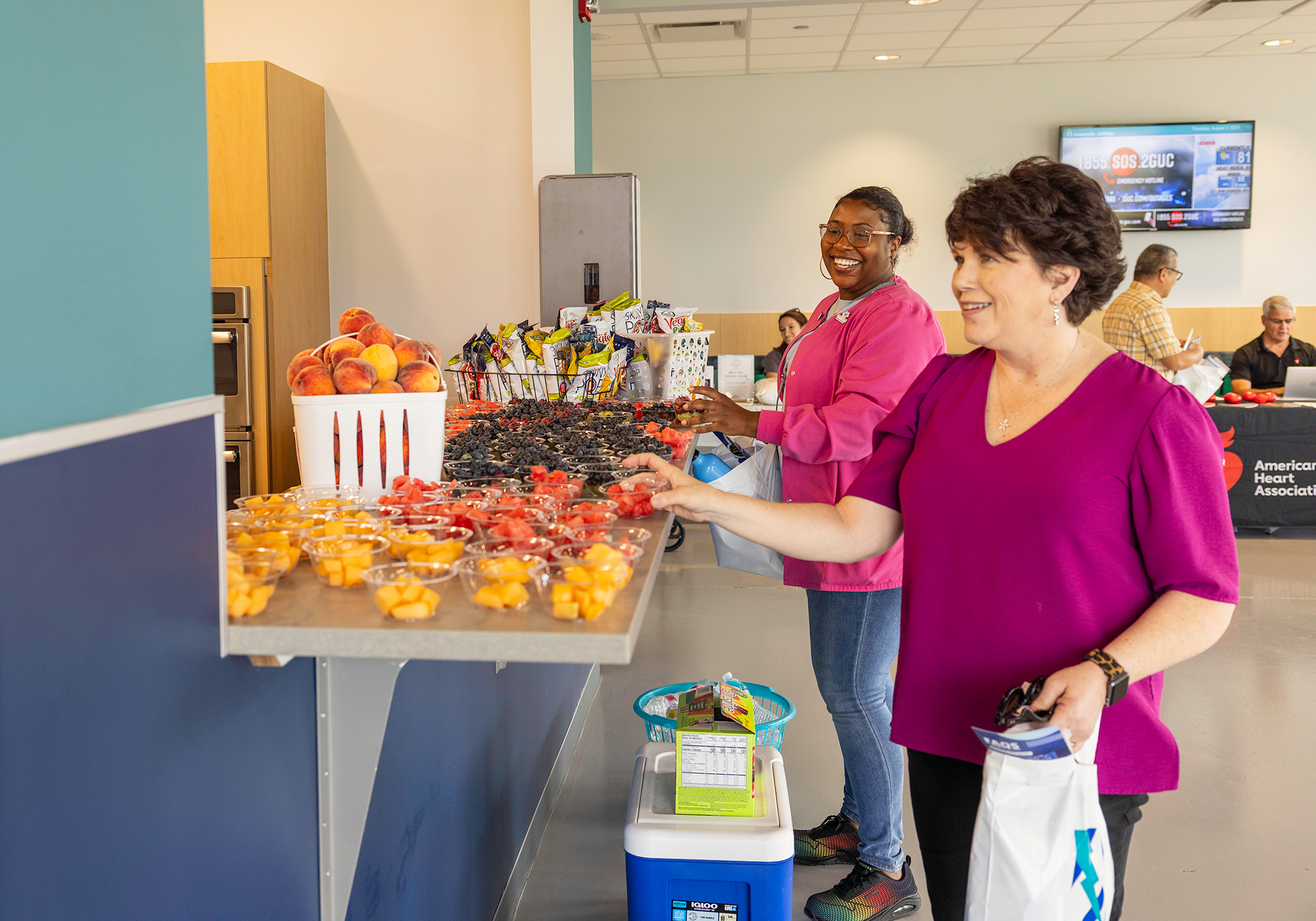 Employees enjoying a cup of fruit at a Wellness Fair